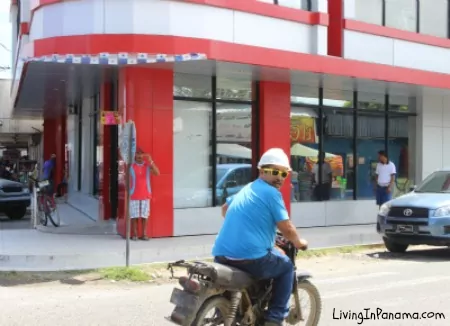 man on motor cycle looking back over shoulder on an urban street