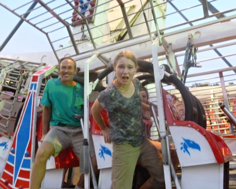 man and girl leaving a fun ride at the fair
