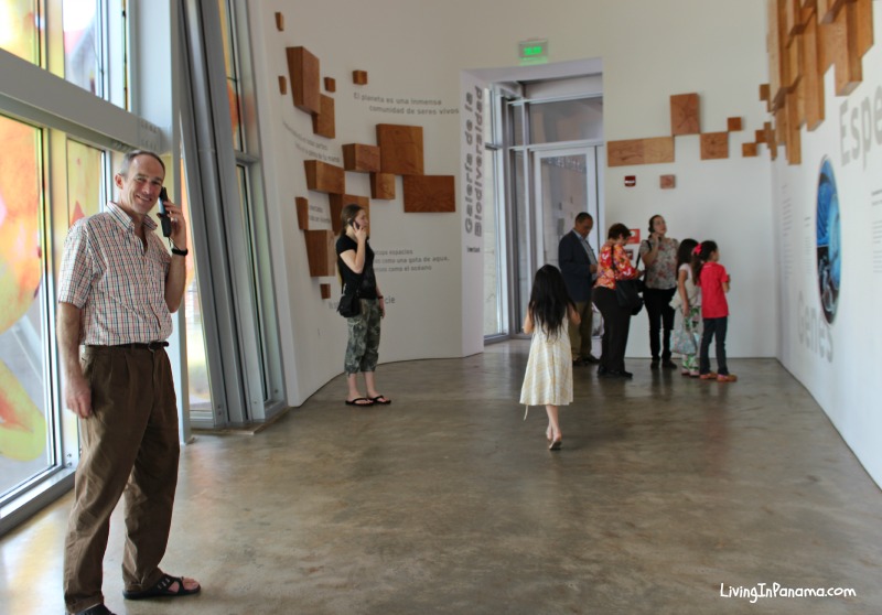 People in big hall in museum with handsets to their ears
