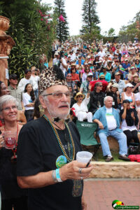 concert with photo of older man with star glassed and leopard patterned fez