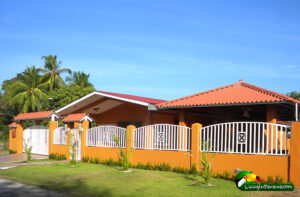 An brown adobe house with tile roof against a blue sky
