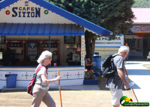 two elderly white people striding through festival