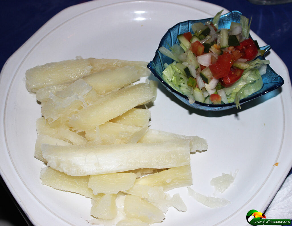 steamed yucca and small salad on white plate