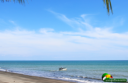 ocean with a fishing boat and blue skies