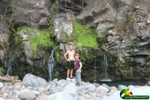 Man and daughter on boulders by river
