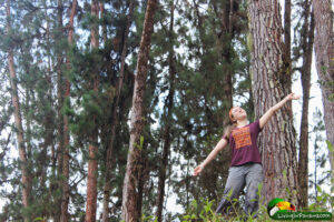 girl posing in front of pine trees