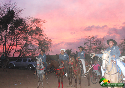 Cowboys on horses at sunset