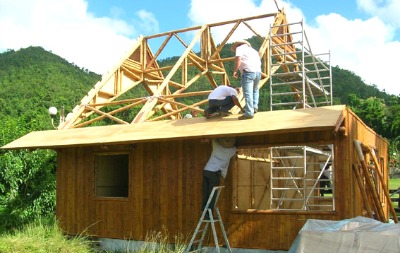 3 men building a house of bamboo