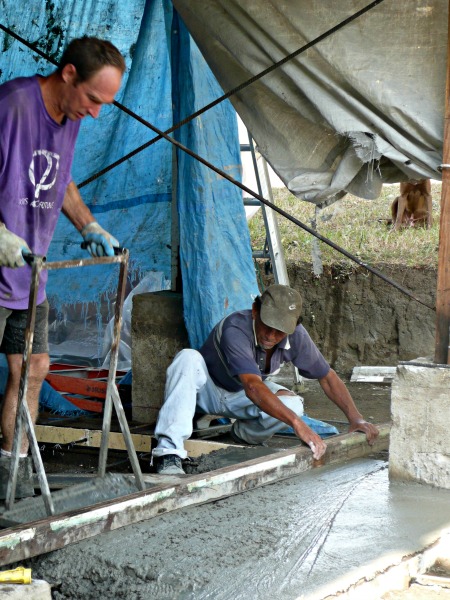 2 men pouring a cement floor & foundation