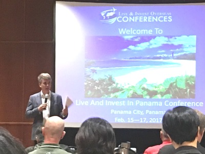 photo of man speaking in front of a screen at a conference