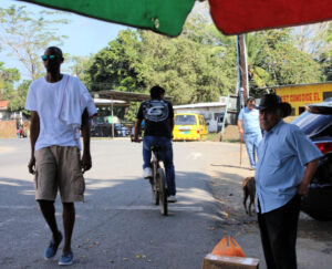 bikers, walkers, and people waiting on street in Puerto Armuelles, Panama