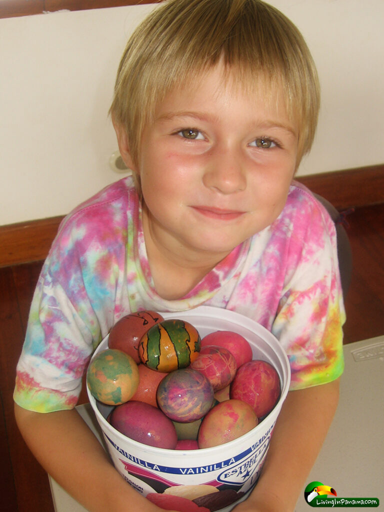 young girl holding a bucket of dyed Easter eggs