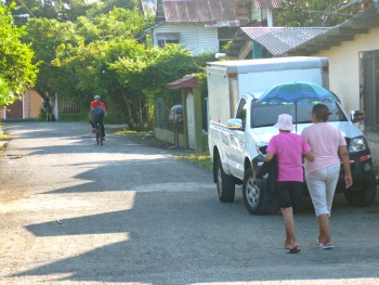 2 women strolling down the street with sun-blocking umbrella